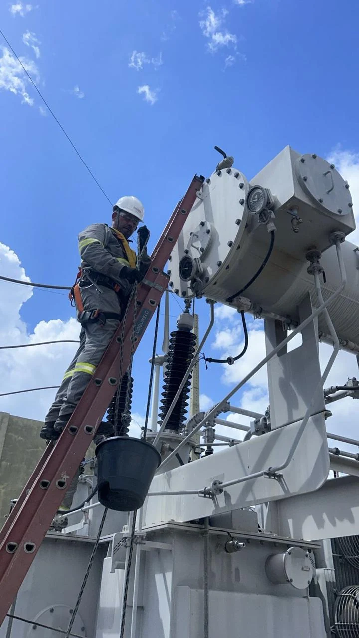Profissional trabalhando no conjunto superior de um transformador